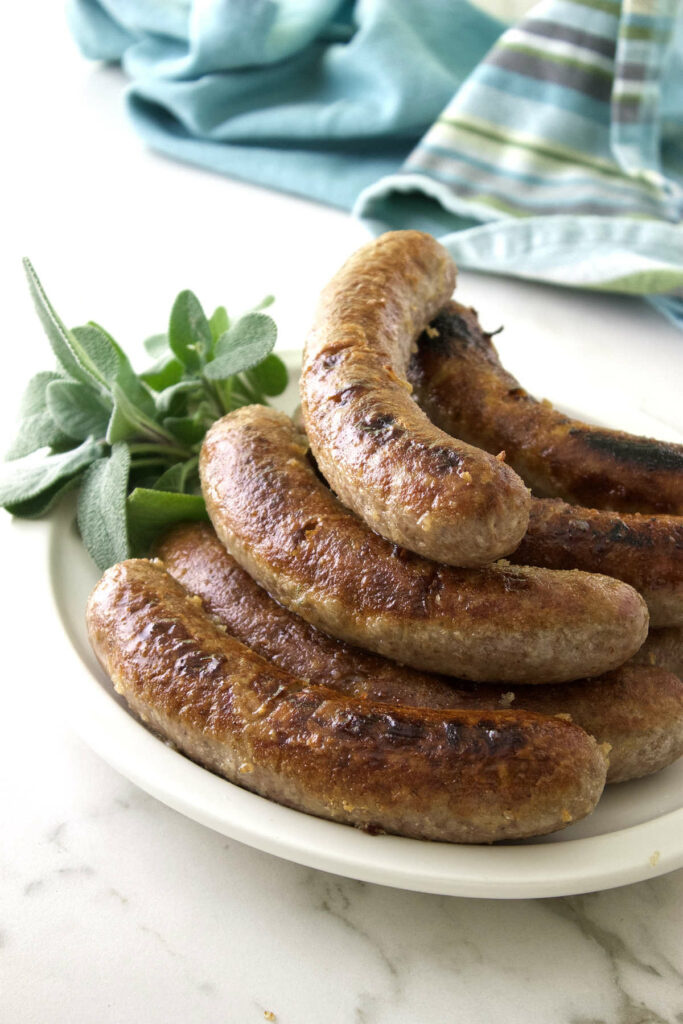 Beer simmered bratwurst on a serving plate.