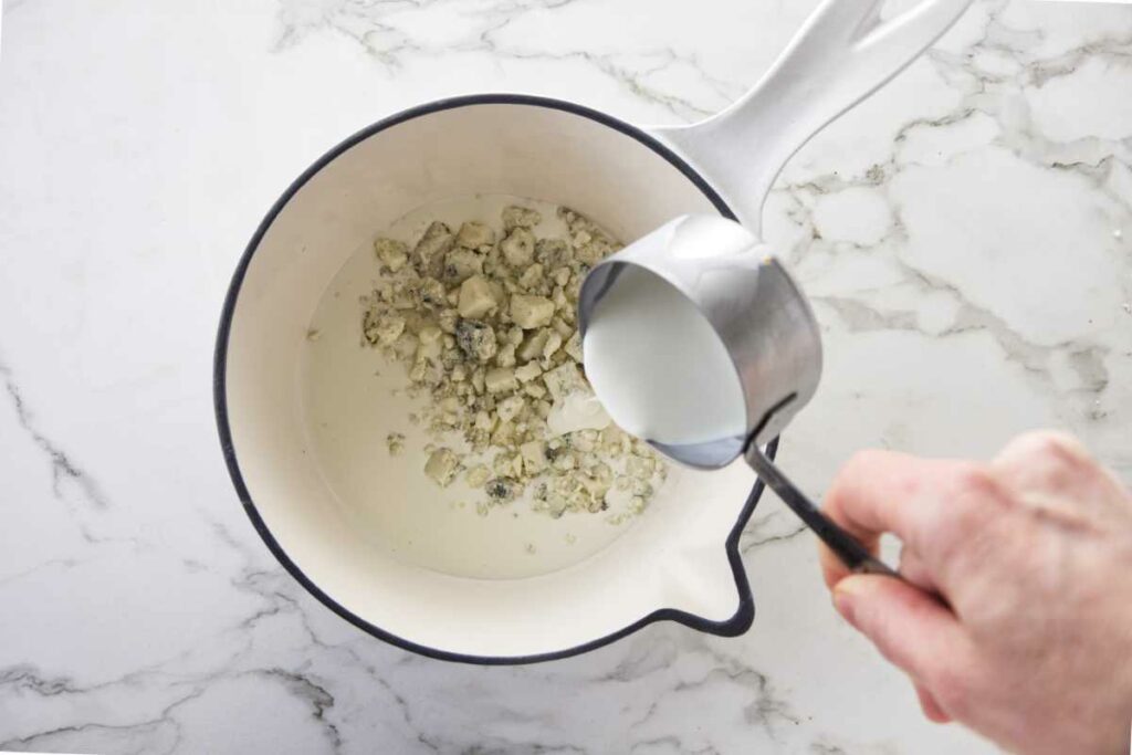 Pouring cream into the saucepan.