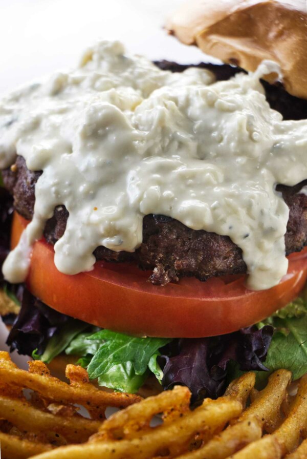 Blue cheese sauce drizzling down a burger.