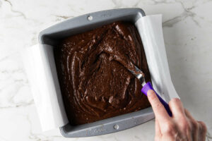 Spreading brownie batter in a baking pan.