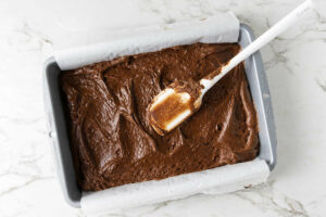 Spreading brownie batter in a 13x9 inch pan.