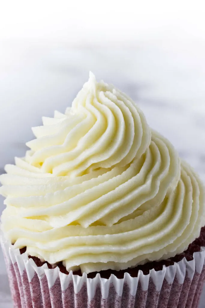 A swirl of cream cheese buttercream frosting on top of a cupcake.