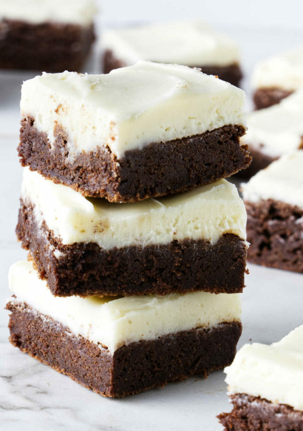 A stack of brownies with cream cheese frosting.