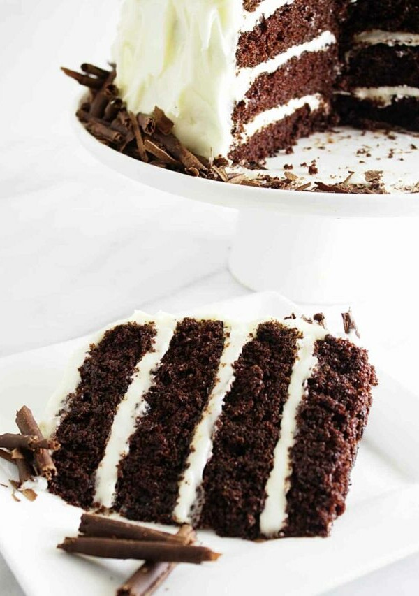 A slice of chocolate cake with cream cheese frosting.