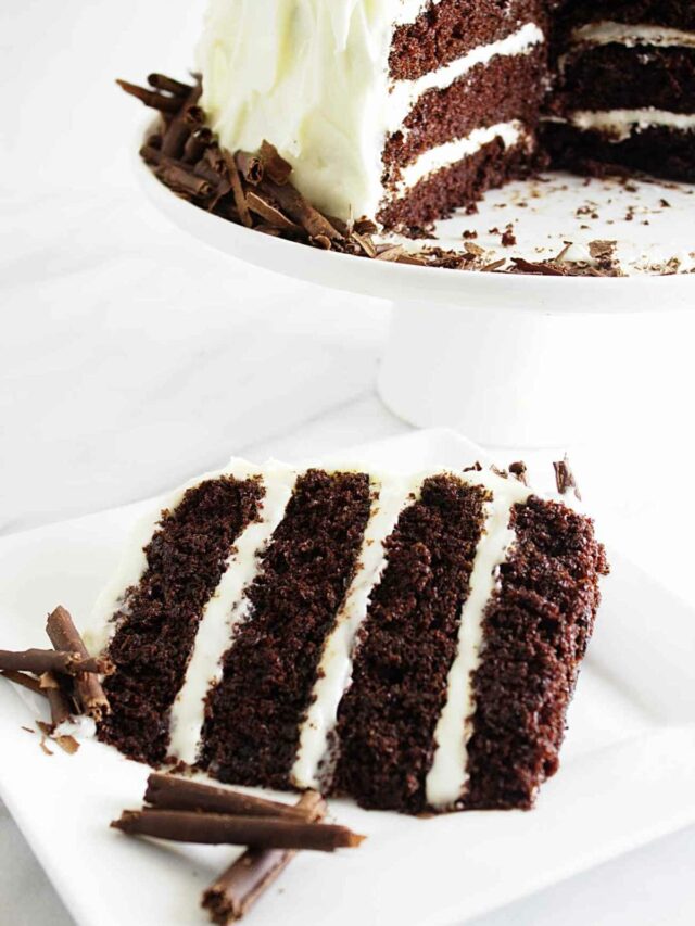 A slice of chocolate cake with cream cheese frosting.