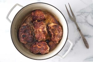 Seering oxtails in a pot.