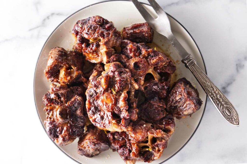 Cooked oxtails on a plate.