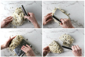 Using a bench scraper to fold and mix the scone dough on the counter then cut the batter into two portions.