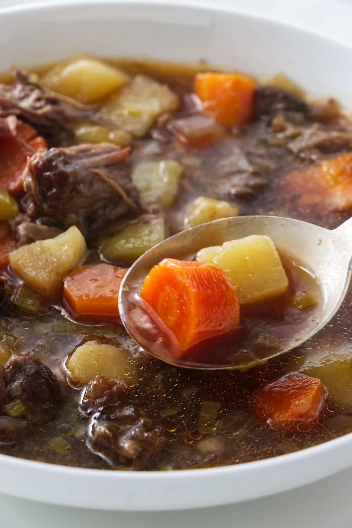 A spoonful of oxtail and vegetable soup.