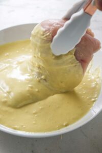 Dipping chicken in dijon batter.