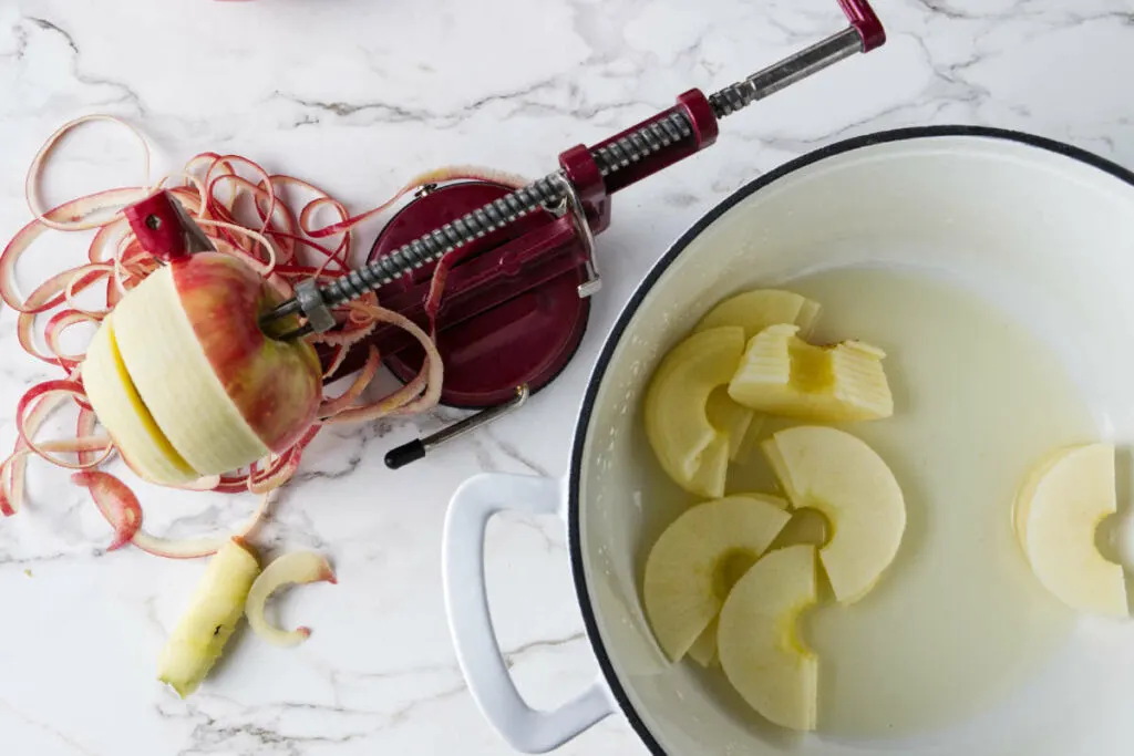 Using an apple peeler to peel, core, and slice apples.