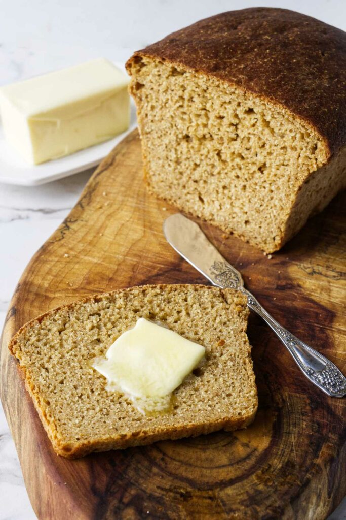 A slice of whole wheat einkorn bread with a pat of butter.