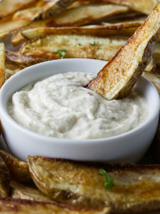 Dipping a French fry in aioli sauce.