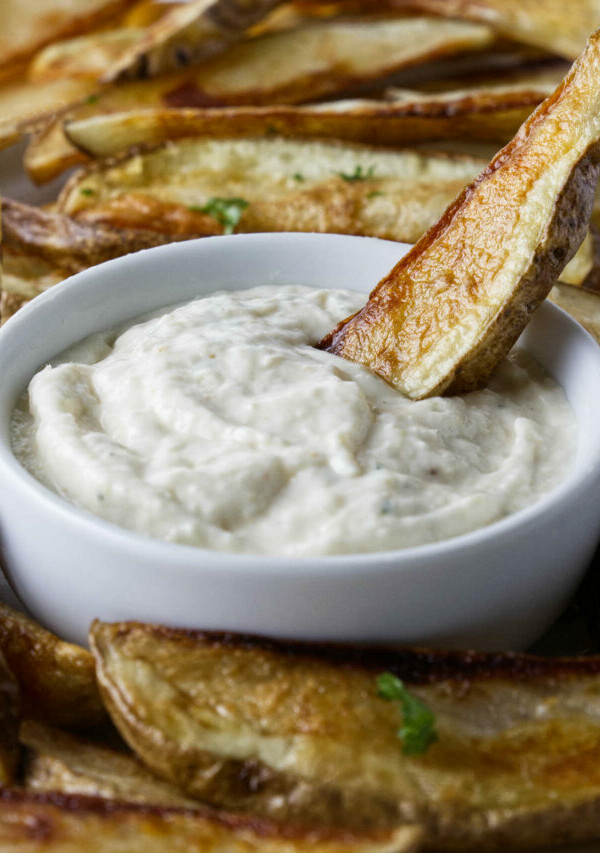 Dipping a French fry in aioli sauce.