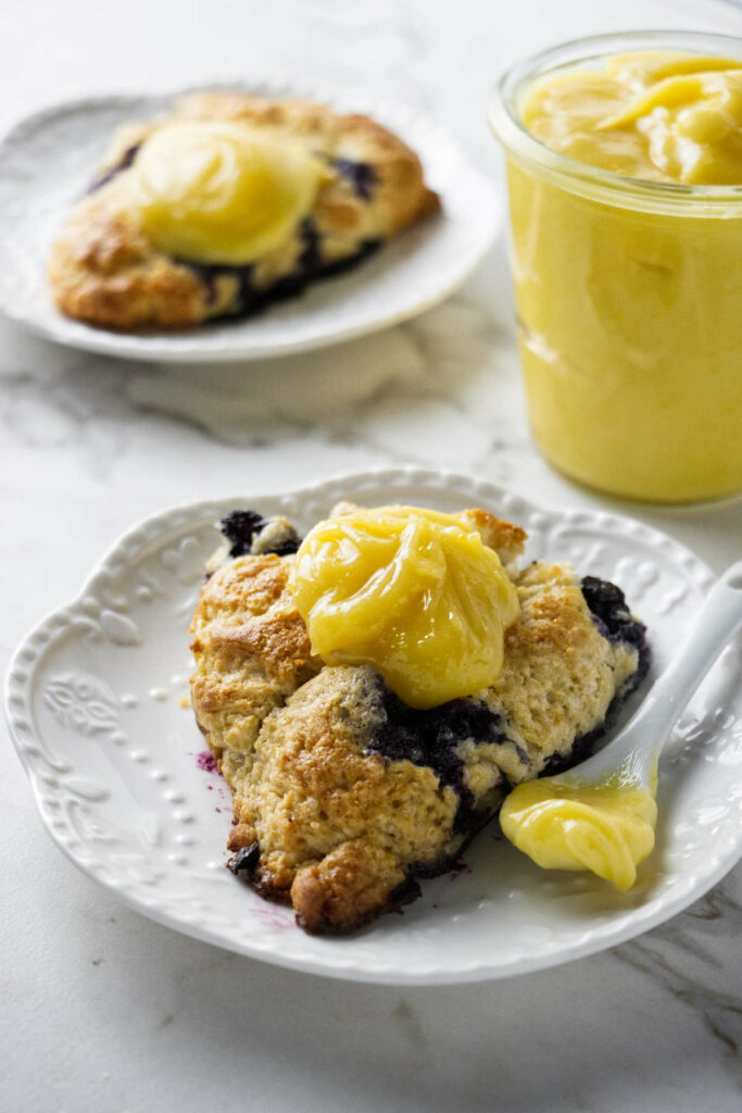 Two scones topped with lemon curd.