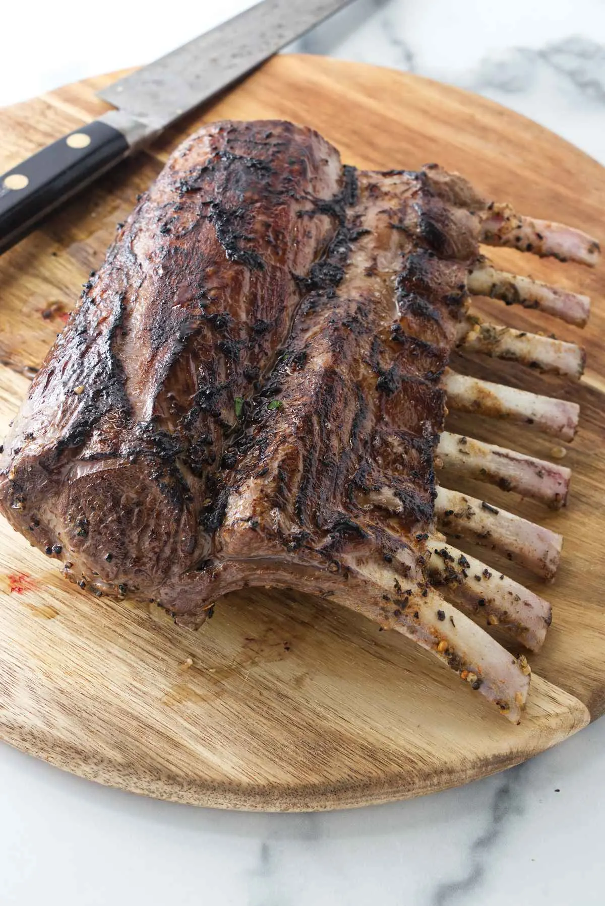 A Frenched rack of lamb on a cutting board.