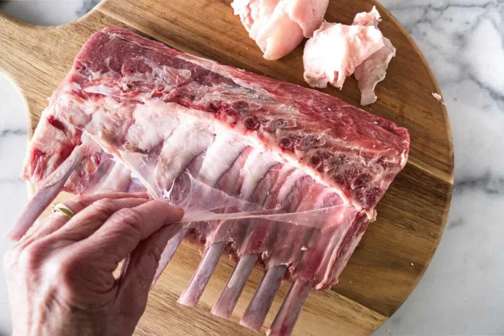 Removing the silver skin from a rack of lamb.