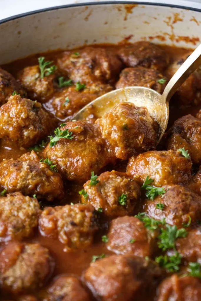 A pot with simmering meatballs.