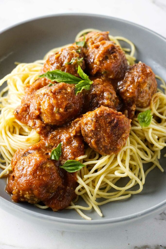 Turkey meatballs in a bowl with spaghetti noodles.