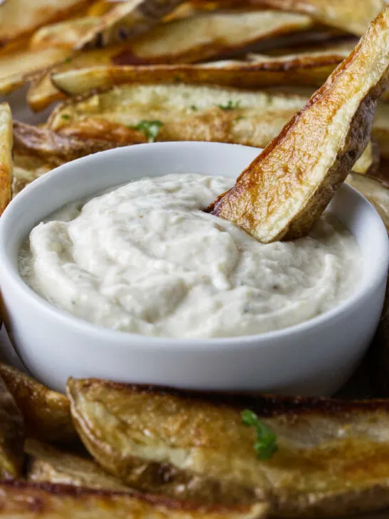 Dipping a French fry in aioli sauce.