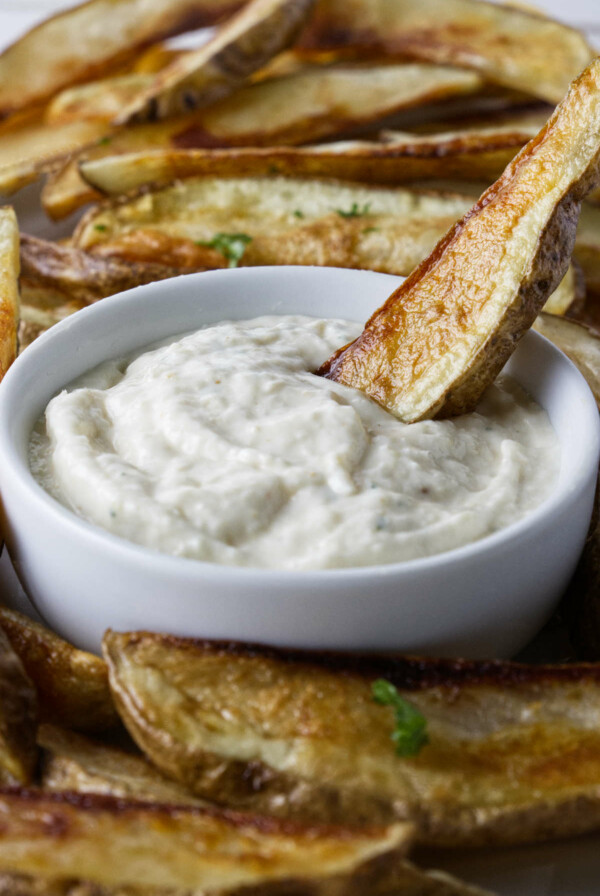 Dipping a French fry in aioli sauce.