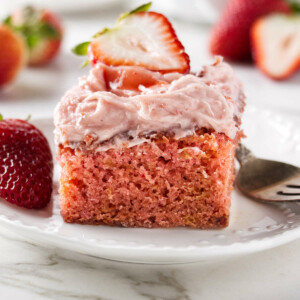 A slice of strawberry jam cake on a white plate.