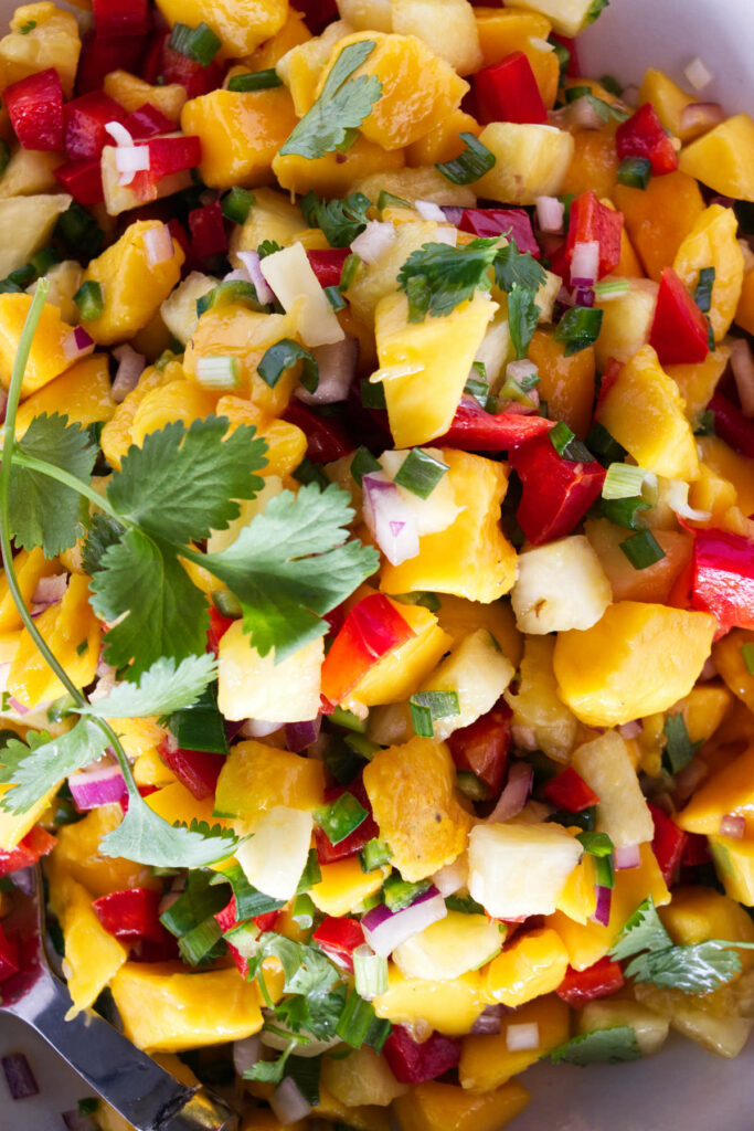 A serving bowl filled with mango and pineapple salsa.