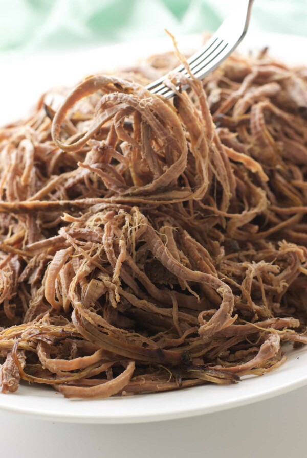 A fork on a pile of shredded tri tip.