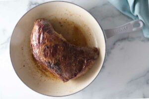Searing a tri tip in a skillet.