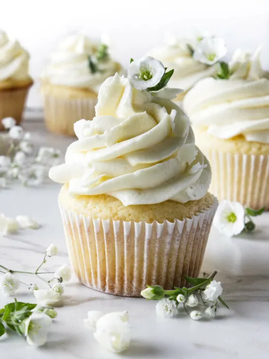 White chocolate cupcakes decorated with small white flowers.