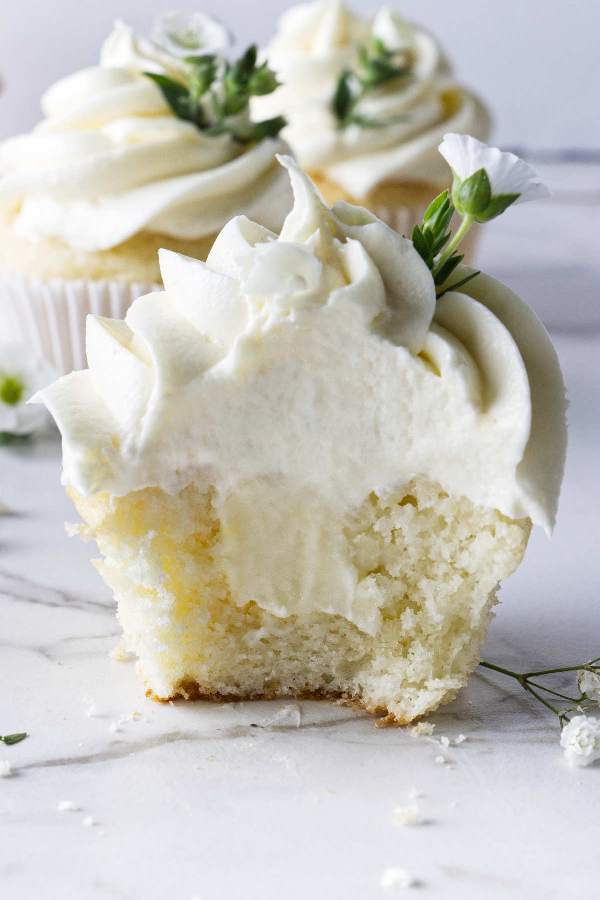 A cupcake sliced open to show teh white chocolate ganache filling in the center.