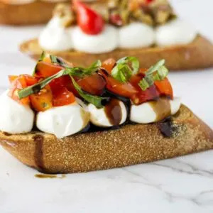 A crostini appetizer with tomatoes.