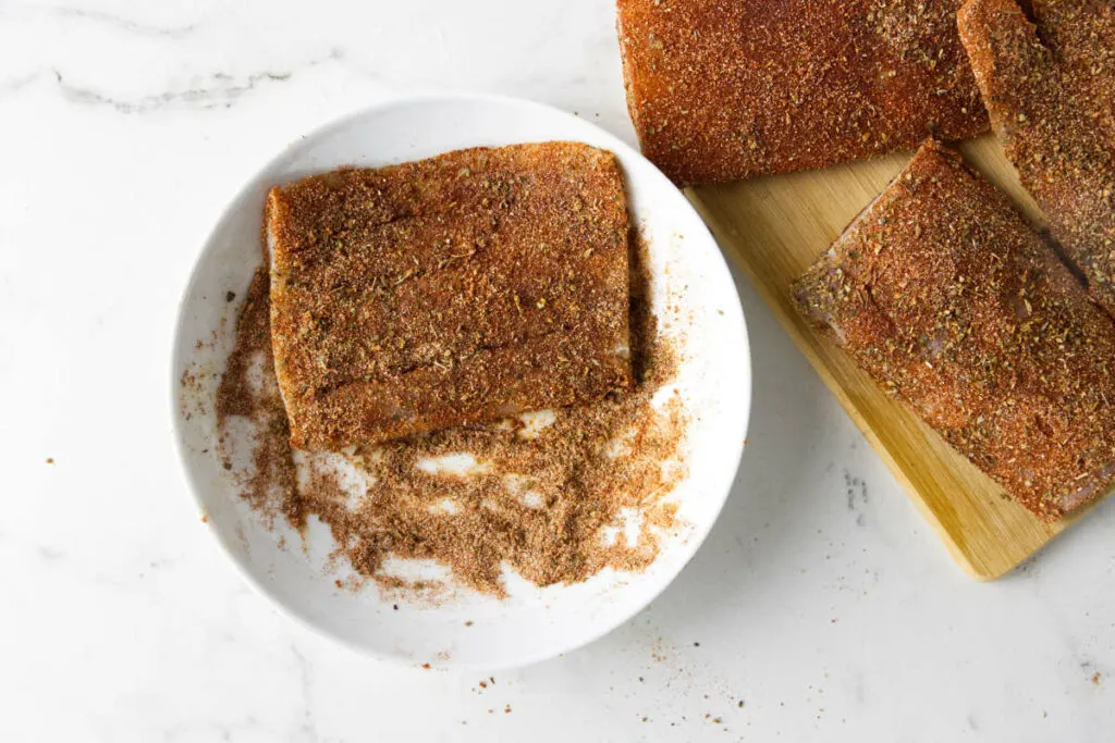 Coating mahi mahi in blackening spices.