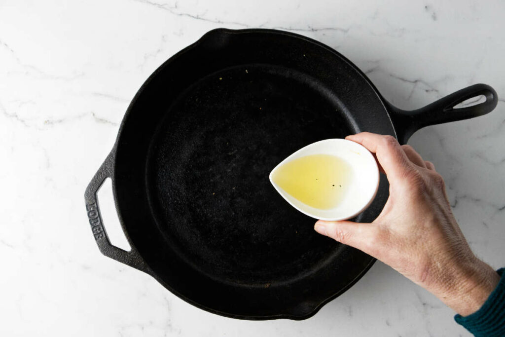 Adding oil to a hot skillet.