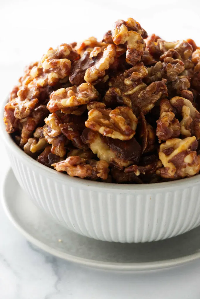 a bowl of brown sugar candied walnuts.