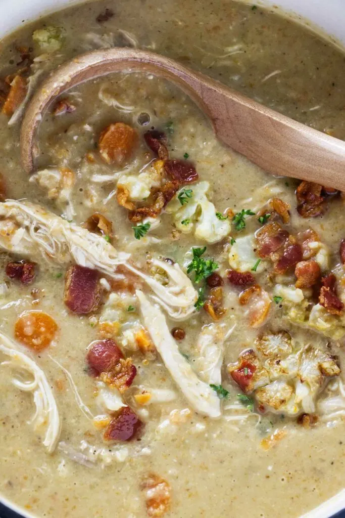A pot of roasted cauliflower soup with chicken and bacon.