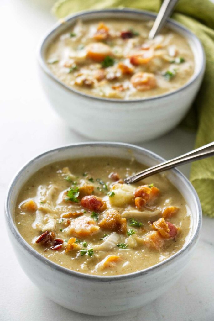 Two bowls of soup with cauliflower and vegetables.