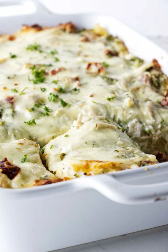 A baking dish with a freshly baked chicken lasagna with broccoli.