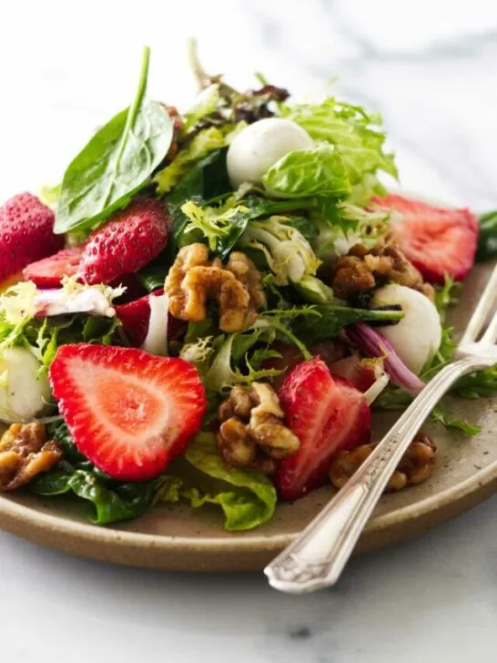 Close view of a serving of strawberry walnut salad.