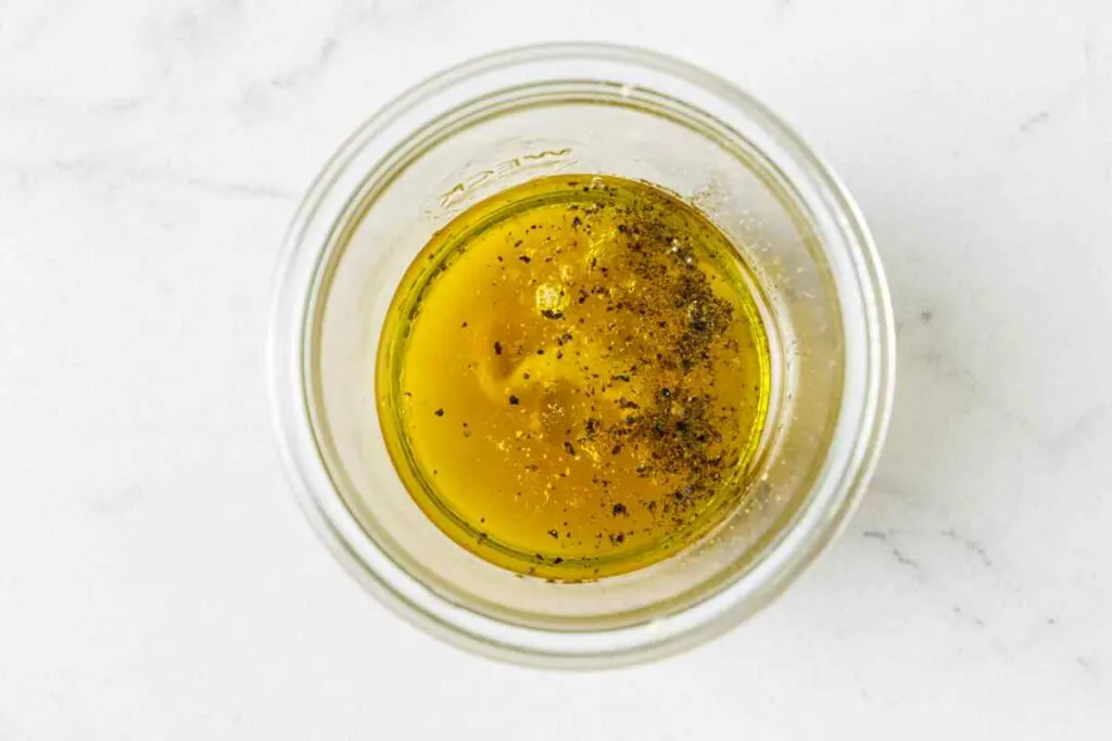 Combining the vinaigrette in a jar.