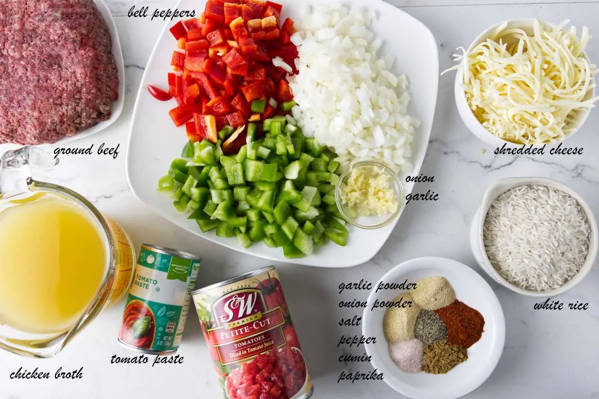 Ingredients for a deconstructed stuffed pepper casserole: bell peppers, shredded cheese, rice, spices, diced tomatoes, tomato paste, chicken broth, and ground beef.