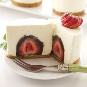 A cheesecake stuffed with a chocolate covered strawberry.