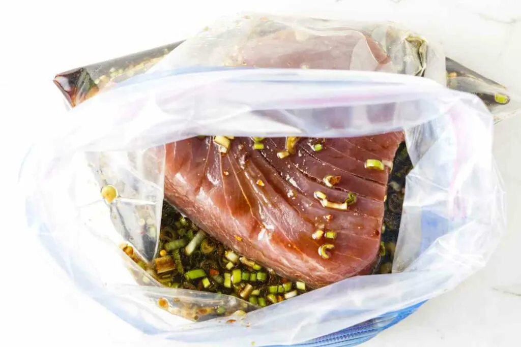 Marinating a tuna steak in a resealable bag.