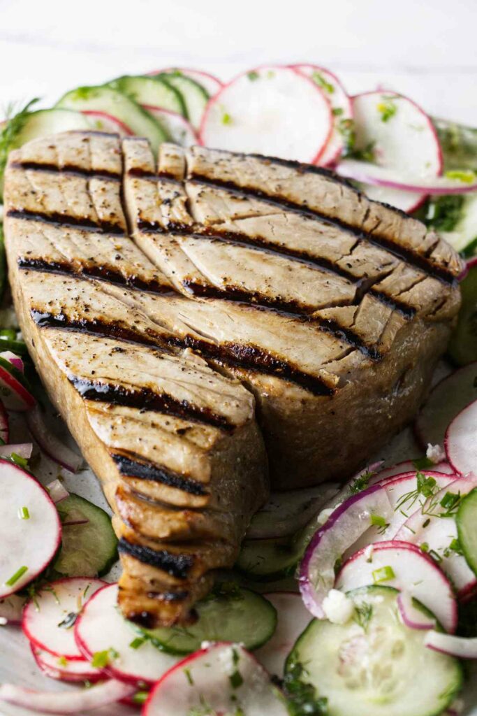A whole tuna steak with grill marks.