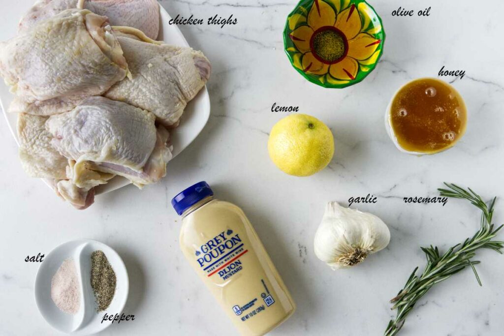 Ingredients for honey herb chicken: chicken thighs, olive oil, honey, rosemary, garlic, dijon, lemon, salt, and pepper.