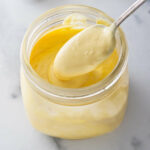 A jar filled with hollandaise sauce.