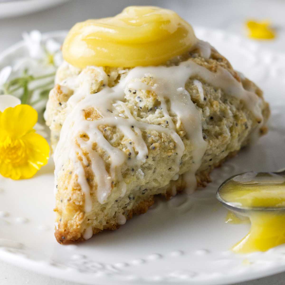 A lemon poppy seeds scone with a dollop of lemon curd on top.