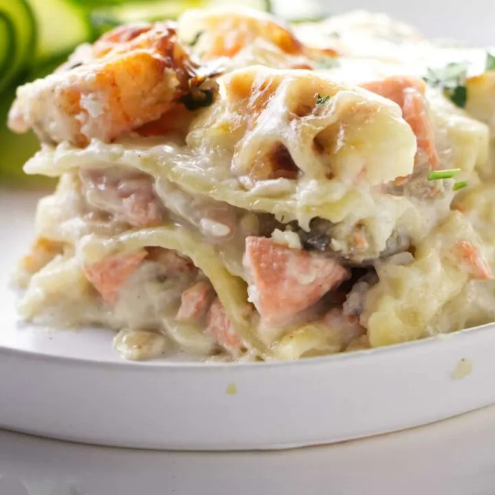 A slice of seafood lasagna showing the layers of noodles and seafood.