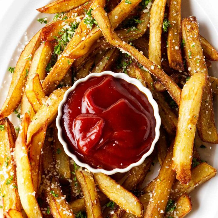 Truffle fries on a plate with a dish of ketchup.