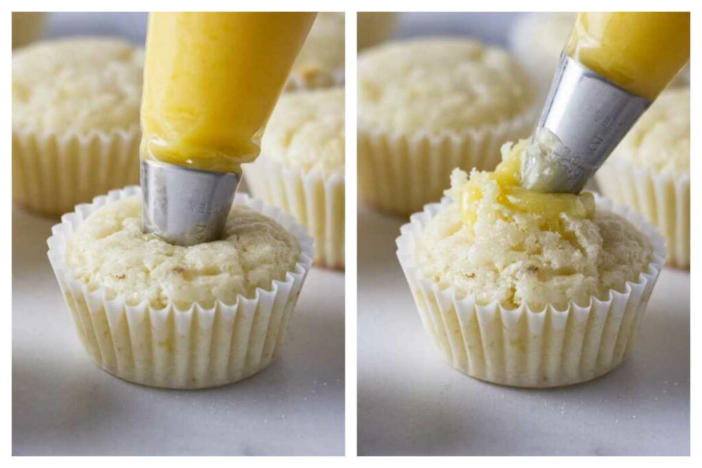 Piping lemon curd into the center of mini cupcakes with a piping bag.